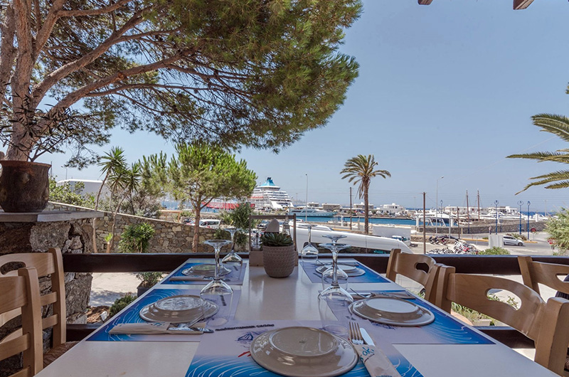 Outdoor terrace dining at Molaraki Restaurant in Tourlos Mykonos with direct view of Mykonos port and marina 03-molaraki-restaurant-mykonos-port-view-tourlos-terrace-dining